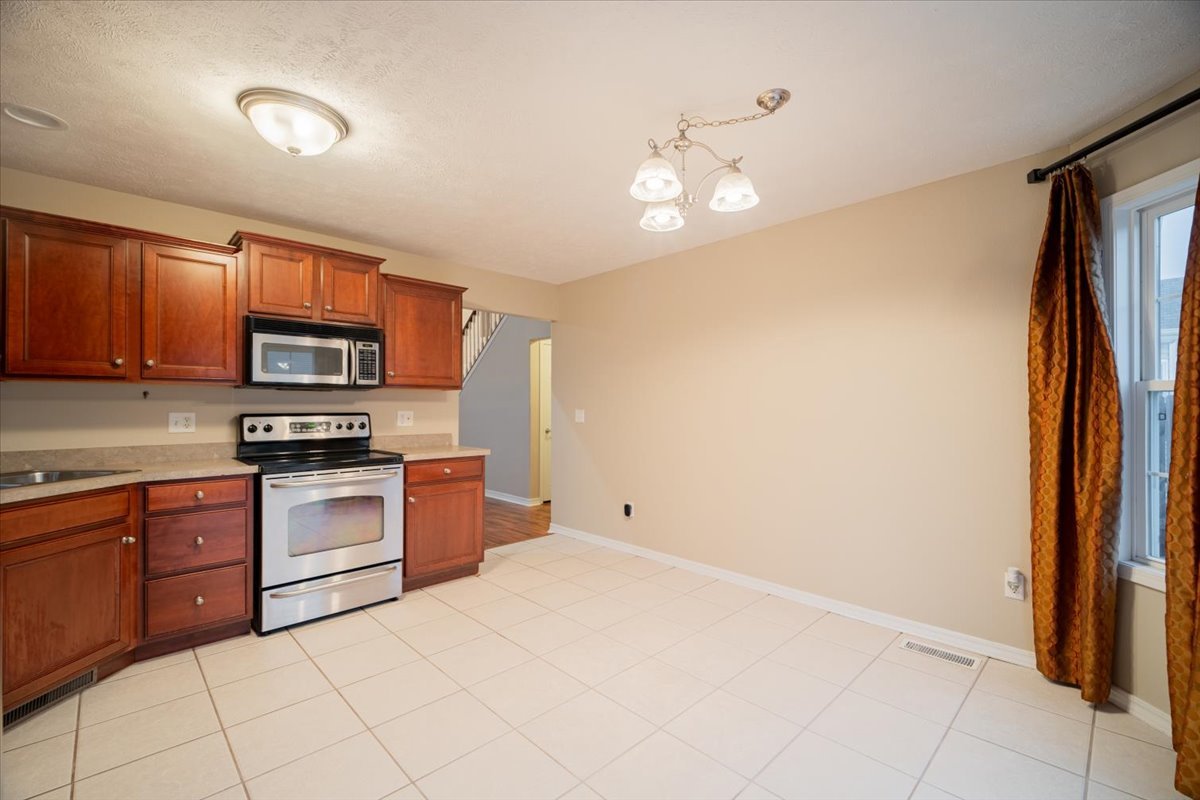 2885 East Raab Road Normal, IL 61761 - Photo 10 of 35 a kitchen with stainless steel appliances granite countertop a refrigerator and a stove top oven
