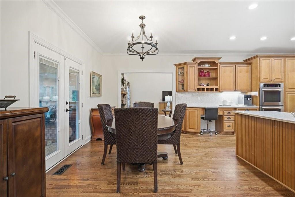 397 Thomas Road Dallas, GA 30132 - Photo 21 of 108 a dining room with wooden floor a chandelier a wooden table and chairs