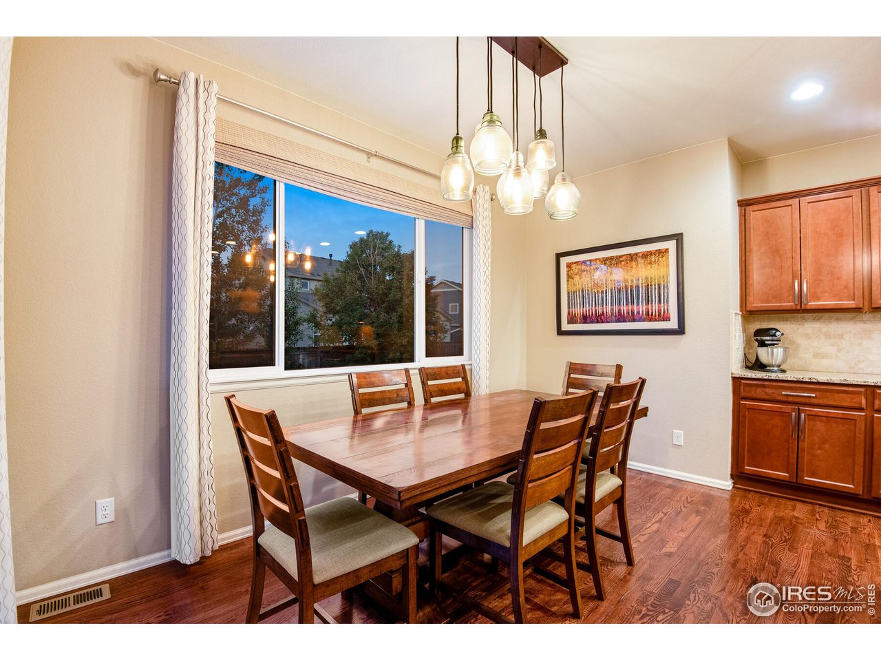 5762 Graphite Street Timnath, CO 80547 - Photo 16 of 27 a dining room with furniture a chandelier and wooden floor