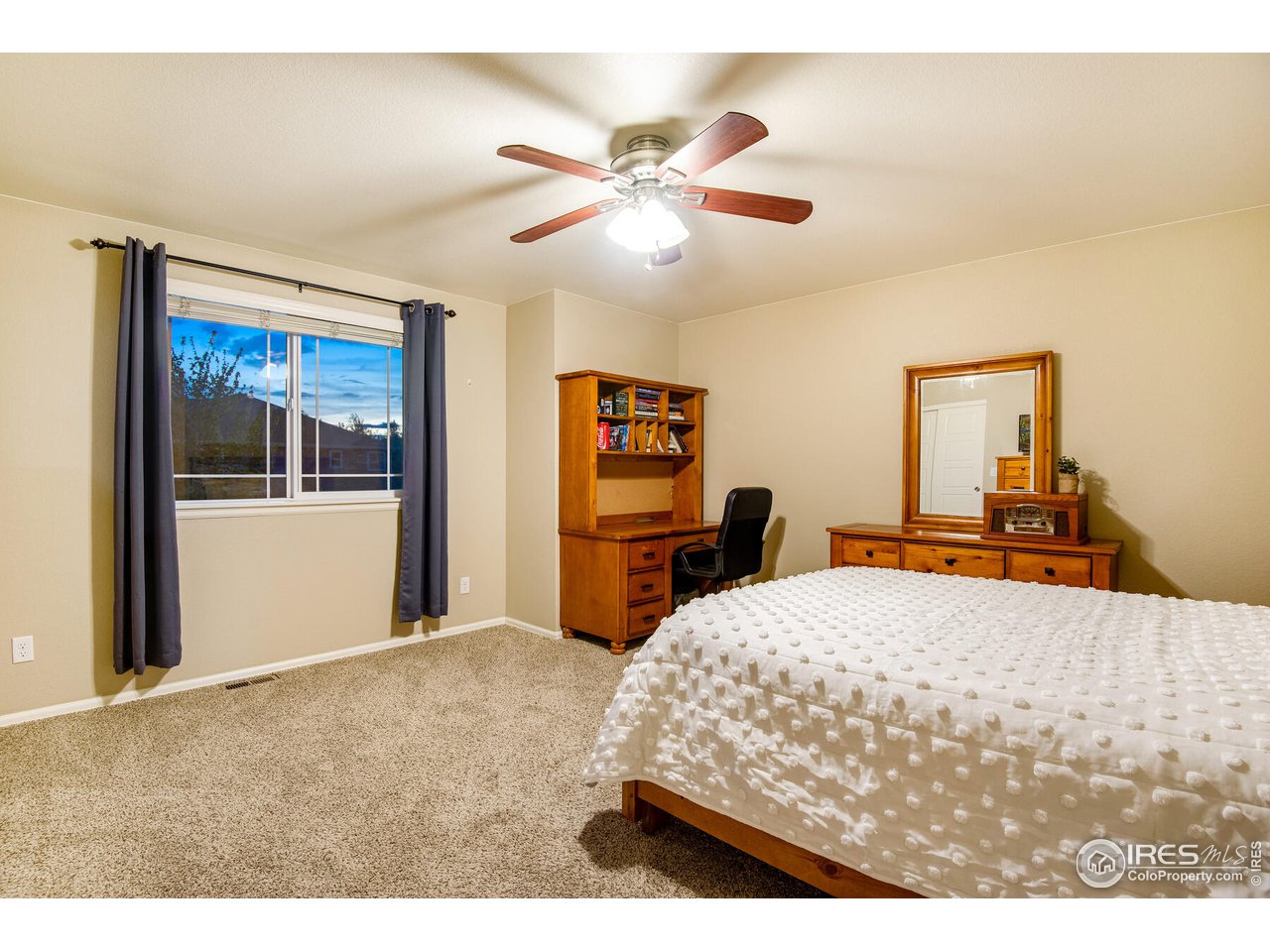 5762 Graphite Street Timnath, CO 80547 - Photo 26 of 27 a bedroom with a bed and a chandelier