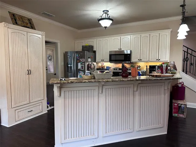 a kitchen with stainless steel appliances granite countertop a refrigerator and a stove