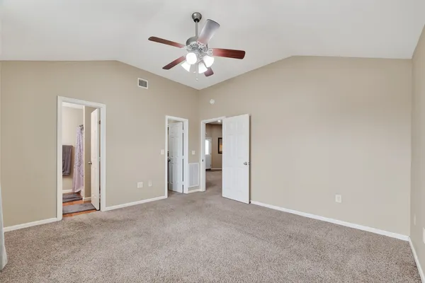 an empty room with chandelier fan