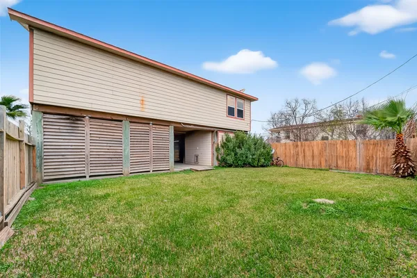 a view of a backyard with plants and wooden fence