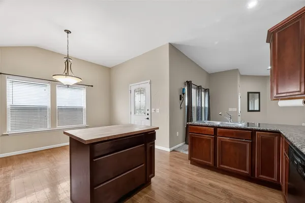 a kitchen with stainless steel appliances granite countertop a sink a stove and a wooden floors