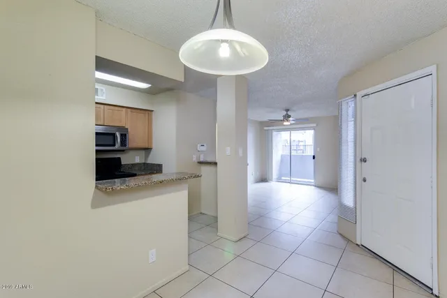 a kitchen with granite countertop wooden cabinets and a stove top oven
