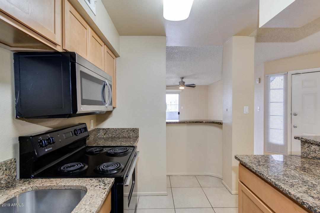 4410 North Longview Avenue, Unit 106 Phoenix, AZ 85014 - Photo 12 of 25 a kitchen with granite countertop a stove and a refrigerator