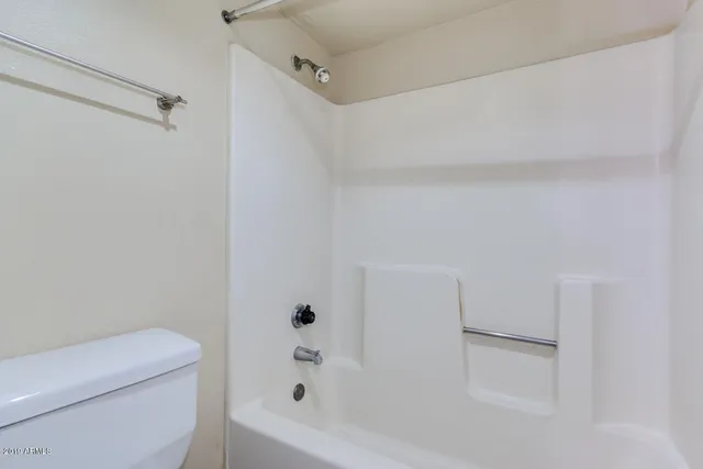 a bathroom with a granite countertop sink a toilet and a mirror