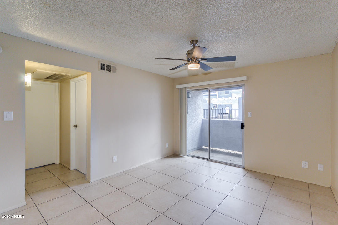 4410 North Longview Avenue, Unit 106 Phoenix, AZ 85014 - Photo 6 of 25 a view of an empty room with window and chandelier fan