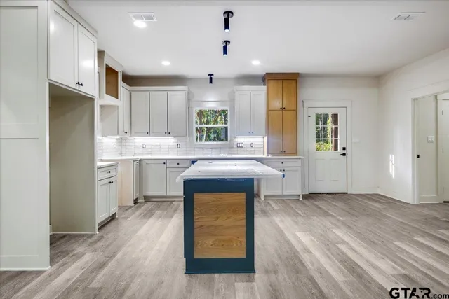a kitchen with a sink a stove cabinets and wooden floor