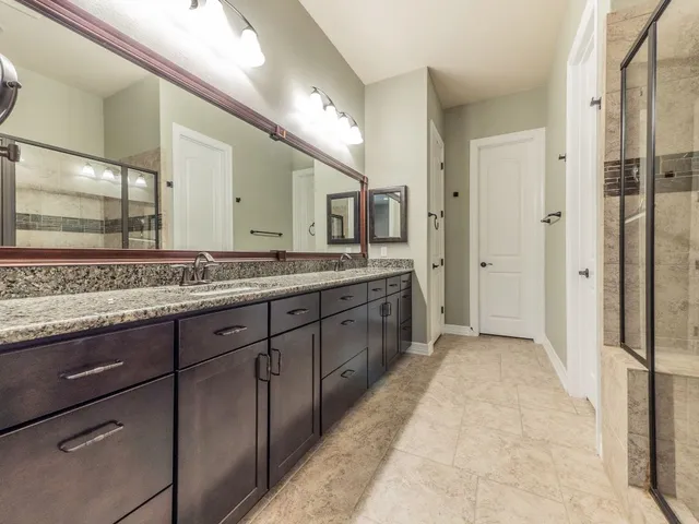a spacious bathroom with a granite countertop sink mirror and double