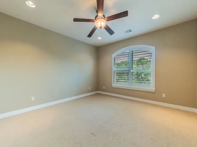 an empty room with a window and a fan