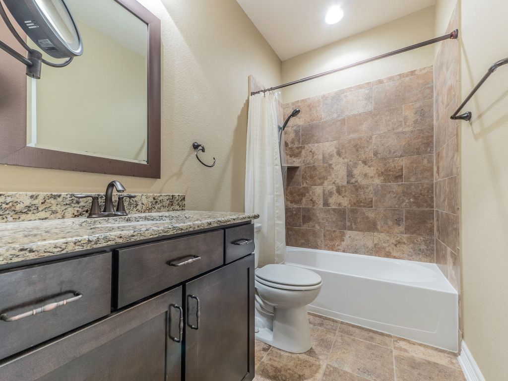 826 San Remo Boulevard Lakeway, TX 78734 - Photo 20 of 25 a bathroom with a granite countertop sink toilet and shower