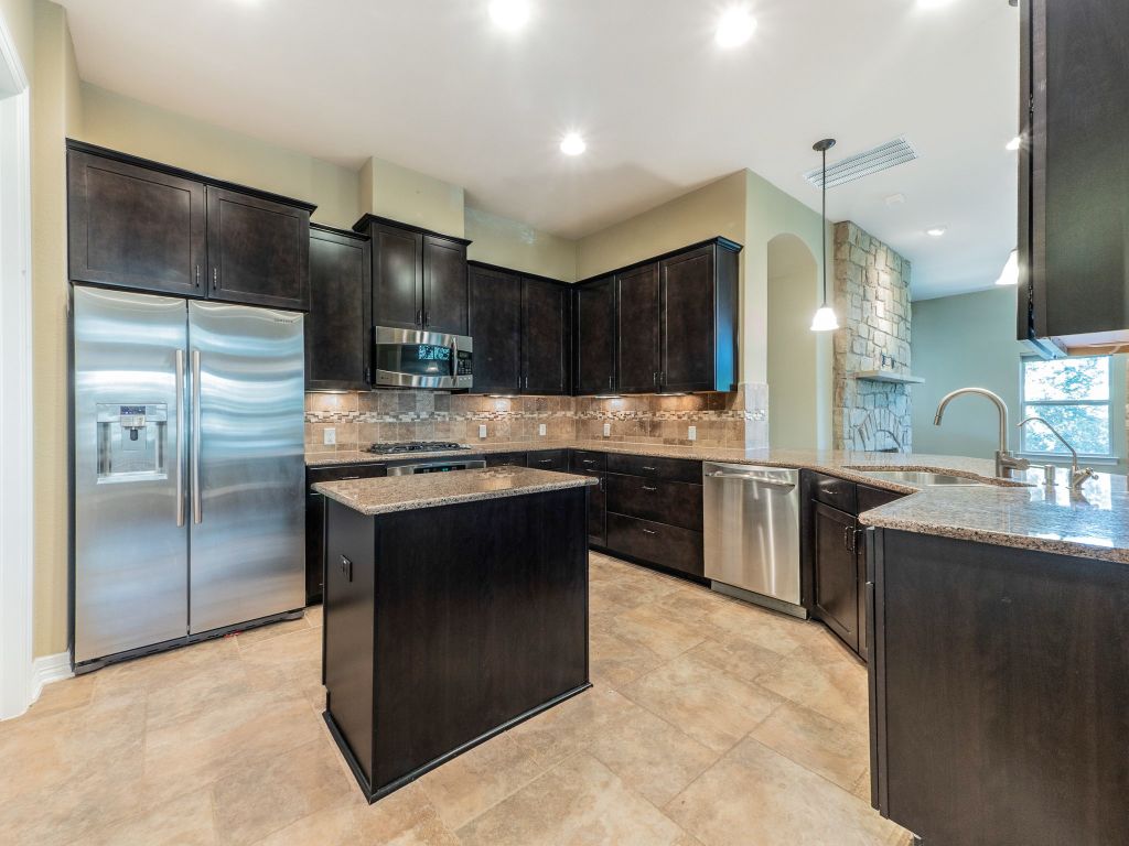 826 San Remo Boulevard Lakeway, TX 78734 - Photo 5 of 25 a kitchen with kitchen island a sink stainless steel appliances and cabinets