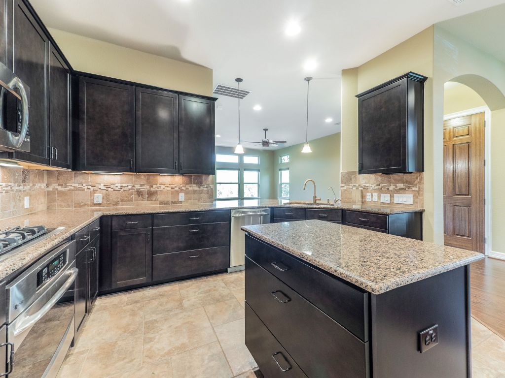 826 San Remo Boulevard Lakeway, TX 78734 - Photo 7 of 25 a kitchen with a stove a sink and a refrigerator