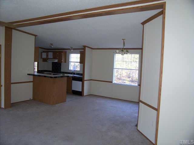 8405 Creek Road Willow Spring, NC 27592 - Photo 3 of 5 a kitchen with stainless steel appliances granite countertop a sink and a stove