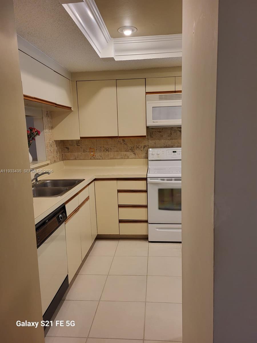 5200 Southeast Seascape Way, Unit 201 Stuart, FL 34997 - Photo 13 of 33 a kitchen with a stove cabinets and a refrigerator