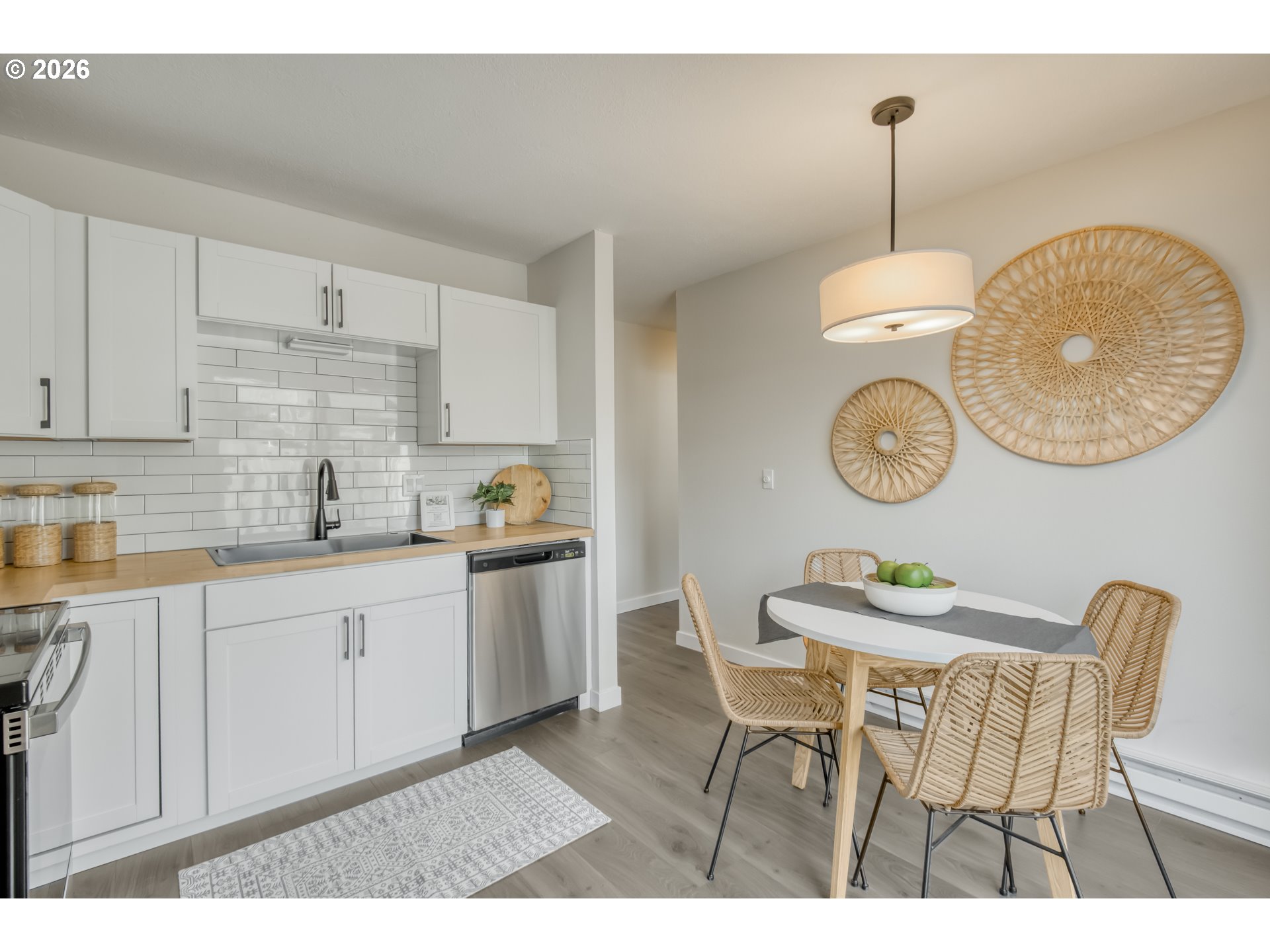 3114 Southwest Carson Street Portland, OR 97219 - Photo 11 of 18 a kitchen with stainless steel appliances granite countertop a sink a stove a dining table and chairs with wooden floor