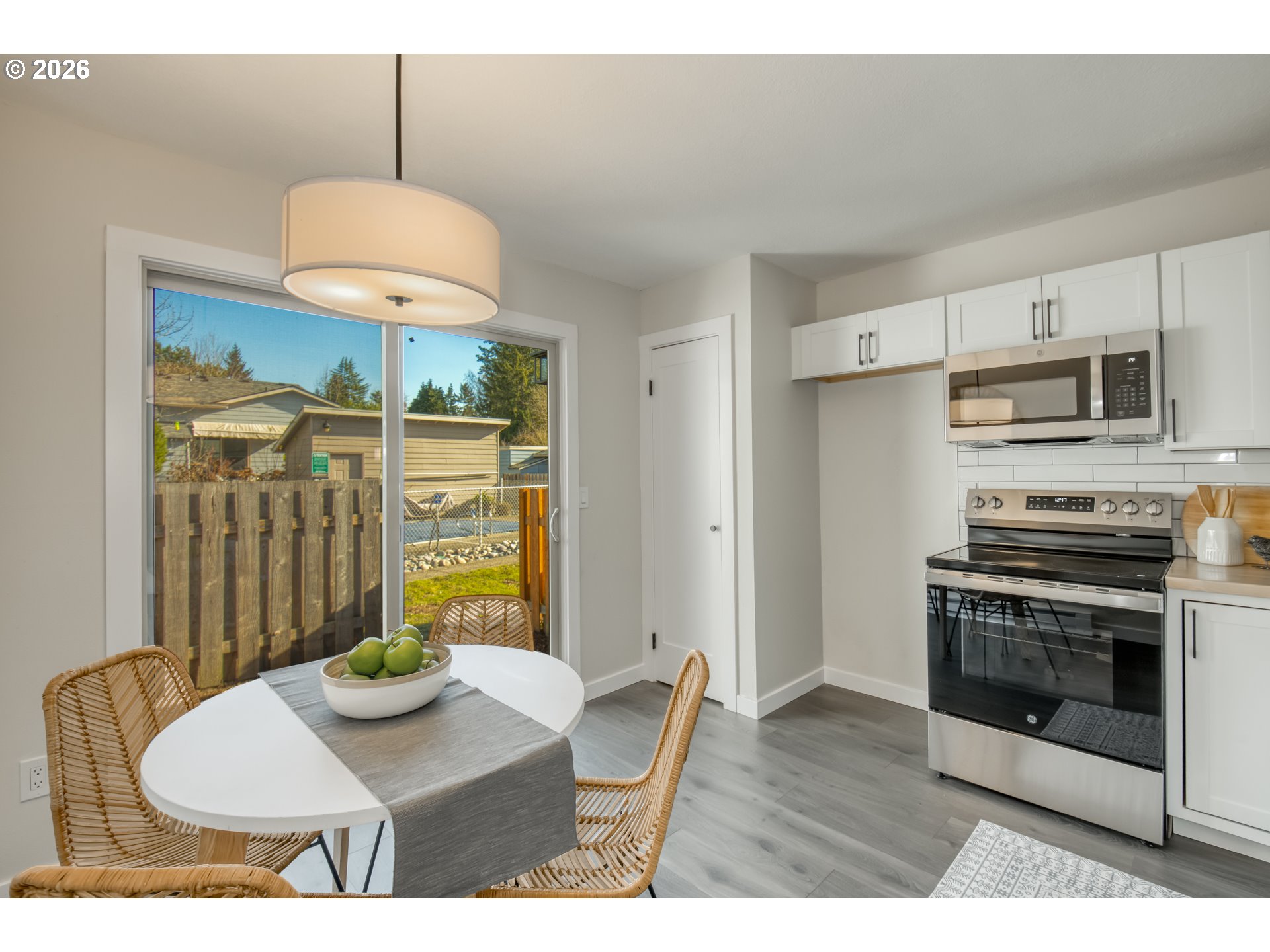 3114 Southwest Carson Street Portland, OR 97219 - Photo 9 of 18 a kitchen with stainless steel appliances granite countertop a sink a stove a dining table and chairs with wooden floor