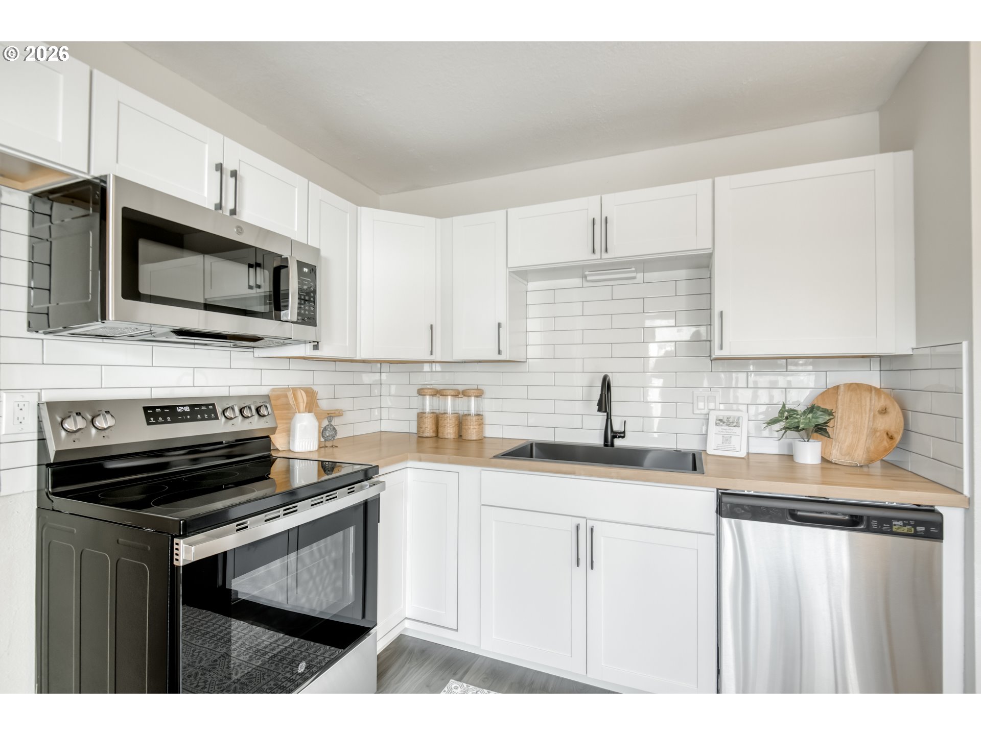 3114 Southwest Carson Street Portland, OR 97219 - Photo 10 of 18 a kitchen with stainless steel appliances a stove sink microwave and cabinets