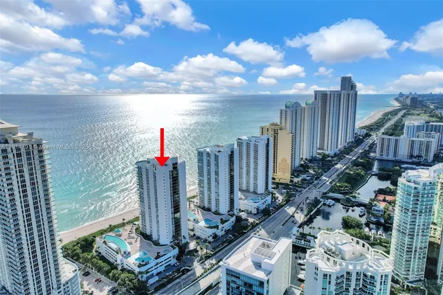 a large white kitchen with a large island oven a sink dishwasher and a fireplace with wooden floor