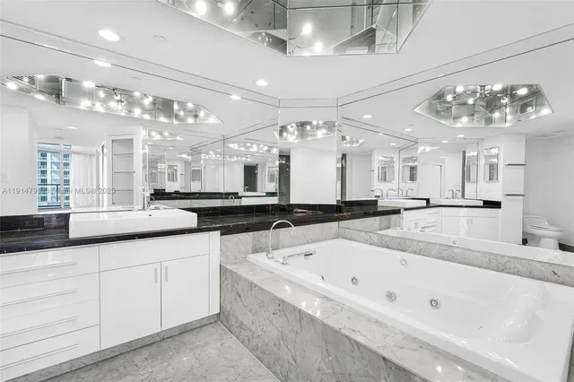 a bathroom with a sink vanity mirror and toilet