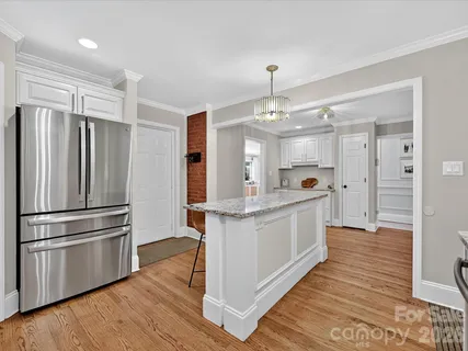 a kitchen with stainless steel appliances a refrigerator and a wooden floors