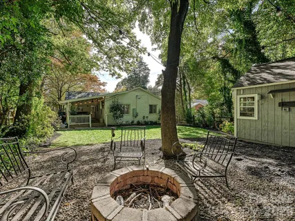 a view of a chair and table in backyard of the house