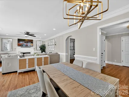 a large white kitchen with a stove a sink dishwasher and a refrigerator with wooden floor