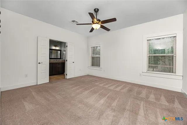 a view of a livingroom with a ceiling fan and window