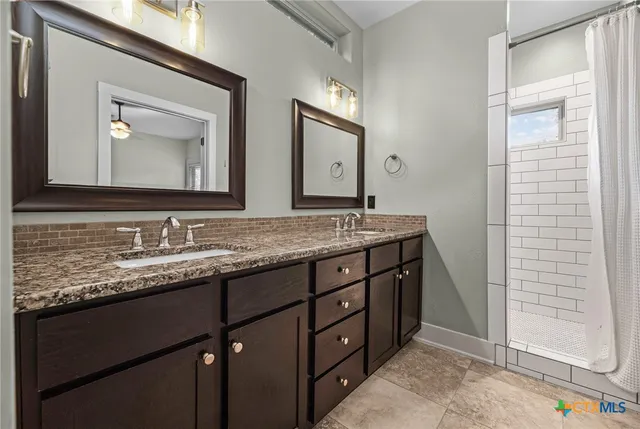 a bathroom with a granite countertop sink vanity and mirror