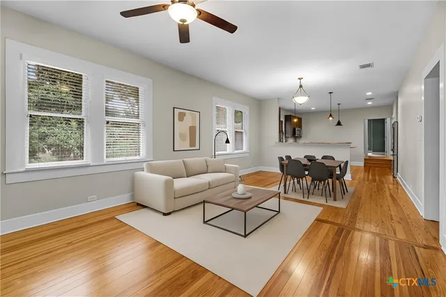 a living room with furniture and a wooden floor