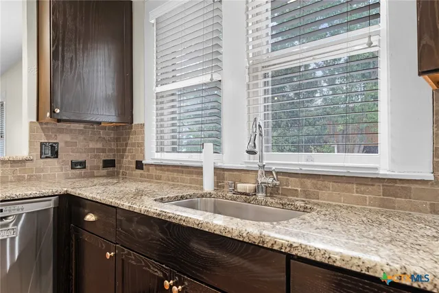 a kitchen with granite countertop a sink and a window