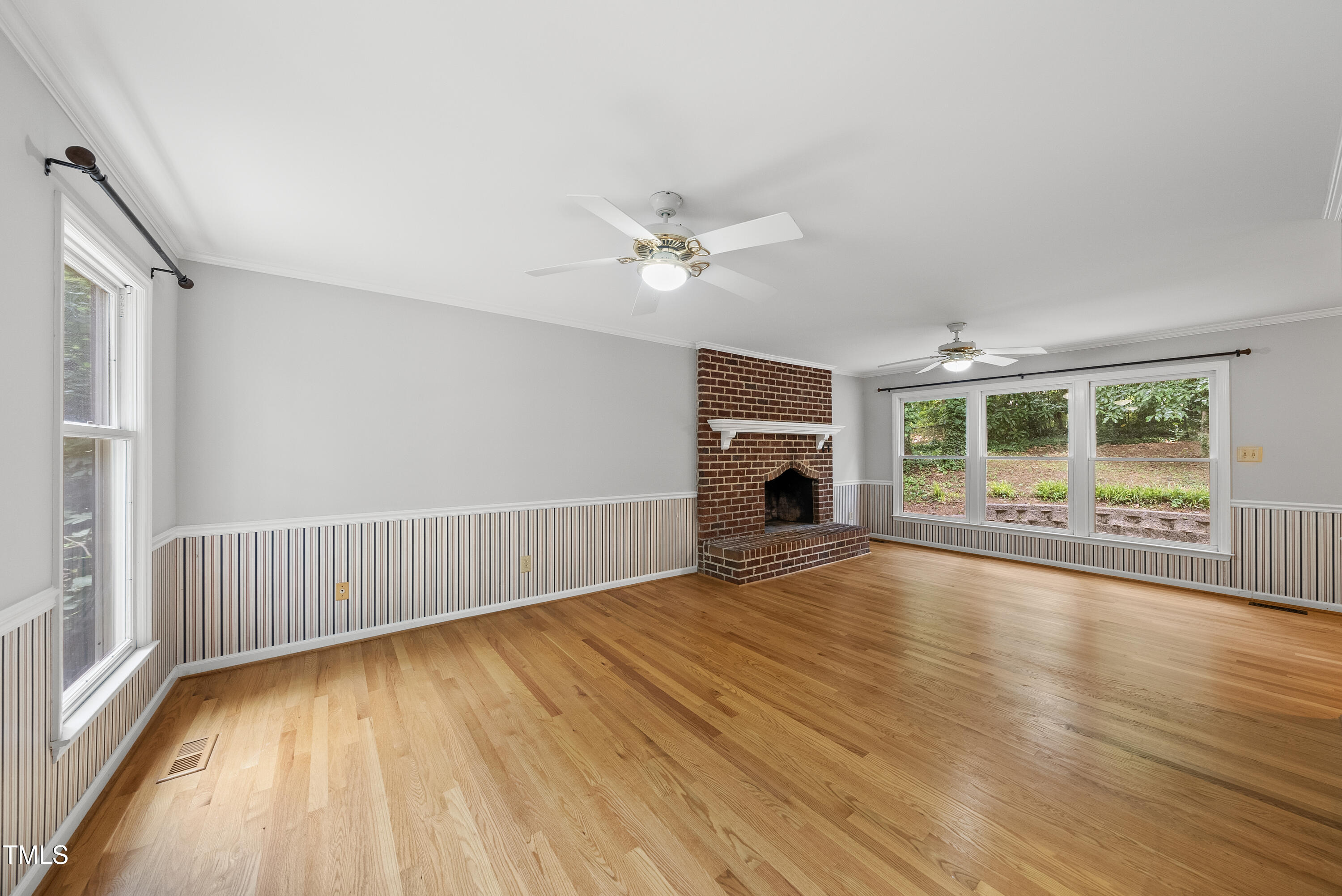 3517 Eden Croft Drive Raleigh, NC 27612 - Photo 3 of 22 wooden floor in an empty room with a fireplace