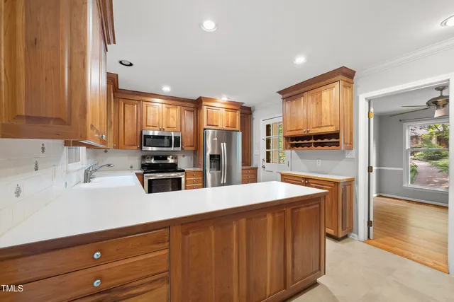 a kitchen with stainless steel appliances wooden cabinets a center island and a refrigerator