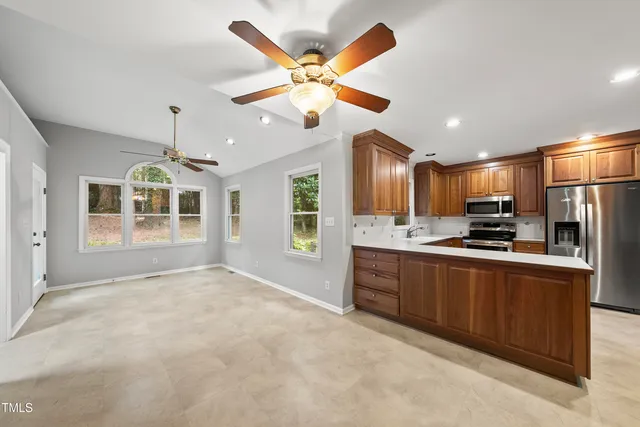 a open kitchen with stainless steel appliances granite countertop a refrigerator a sink dishwasher with a stove and a refrigerator