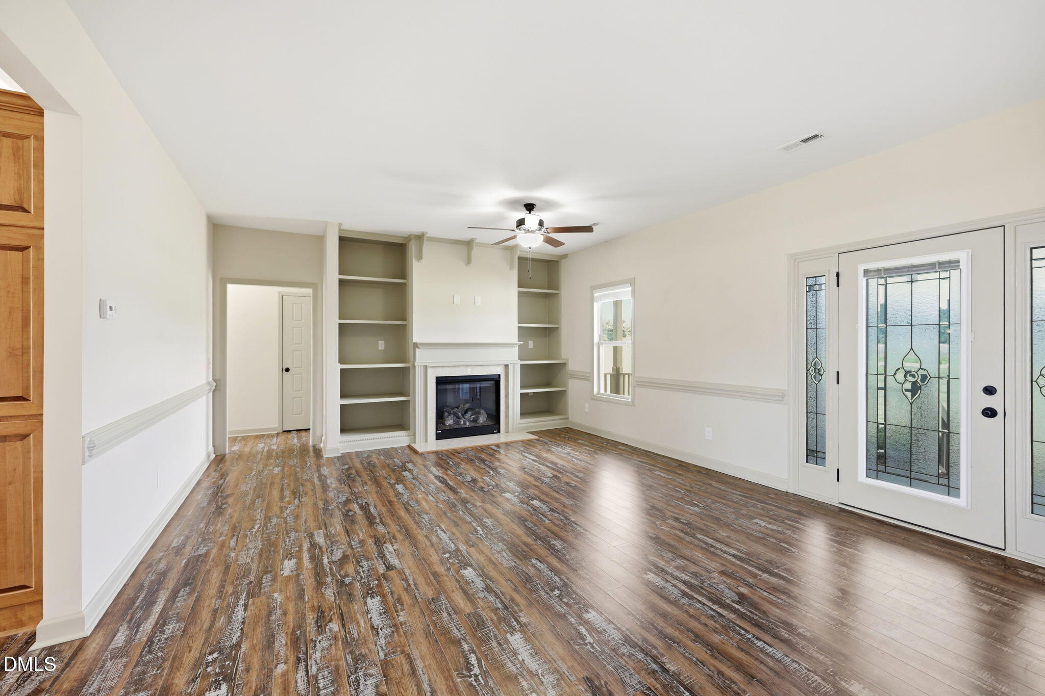 3587 Hannah Creek Road Benson, NC 27504 - Photo 5 of 43 an empty room with wooden floor fireplace and windows