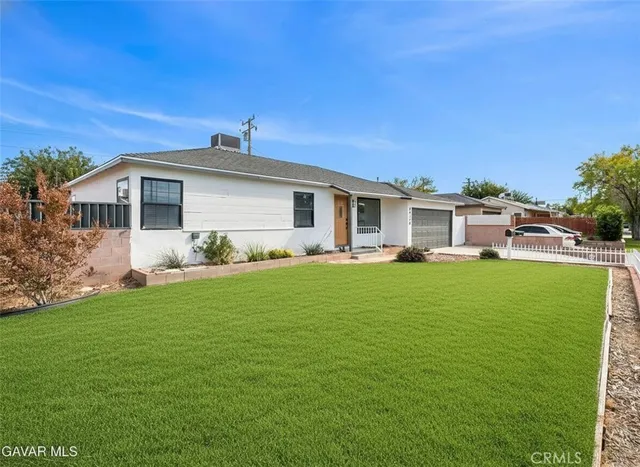 a front view of a house with a yard and potted plants