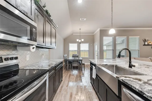 a kitchen with stainless steel appliances granite countertop a stove top oven a sink with granite countertops and cabinets