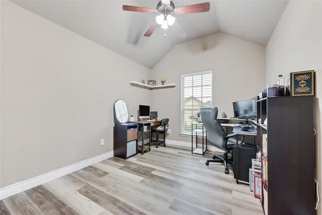 a view of workspace with wooden floor windows and fan