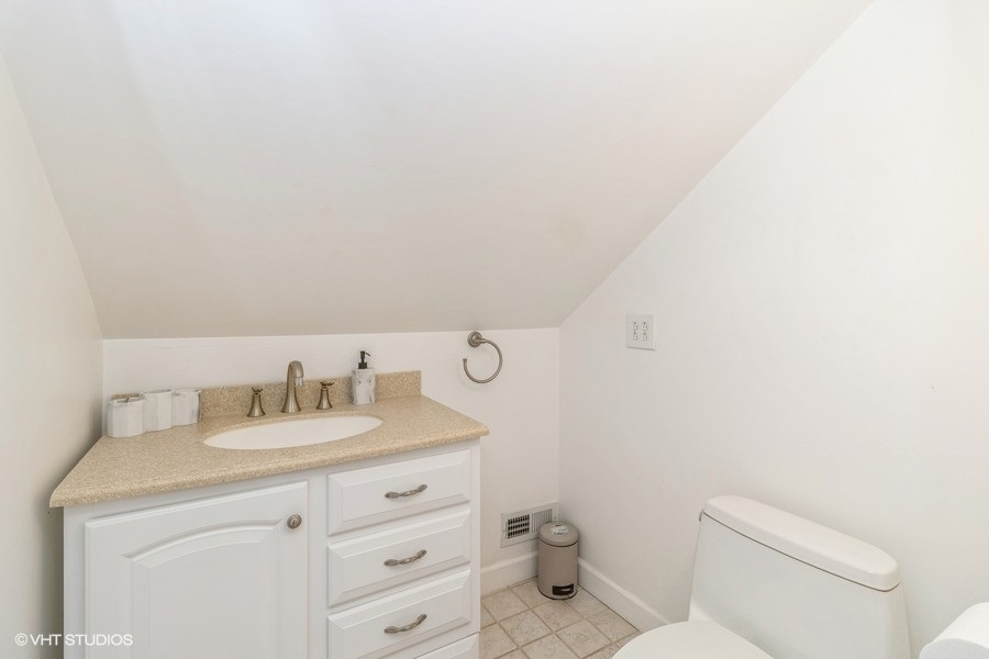 6129 North Mason Avenue Chicago, IL 60646 - Photo 13 of 22 a bathroom with a toilet sink vanity and mirror