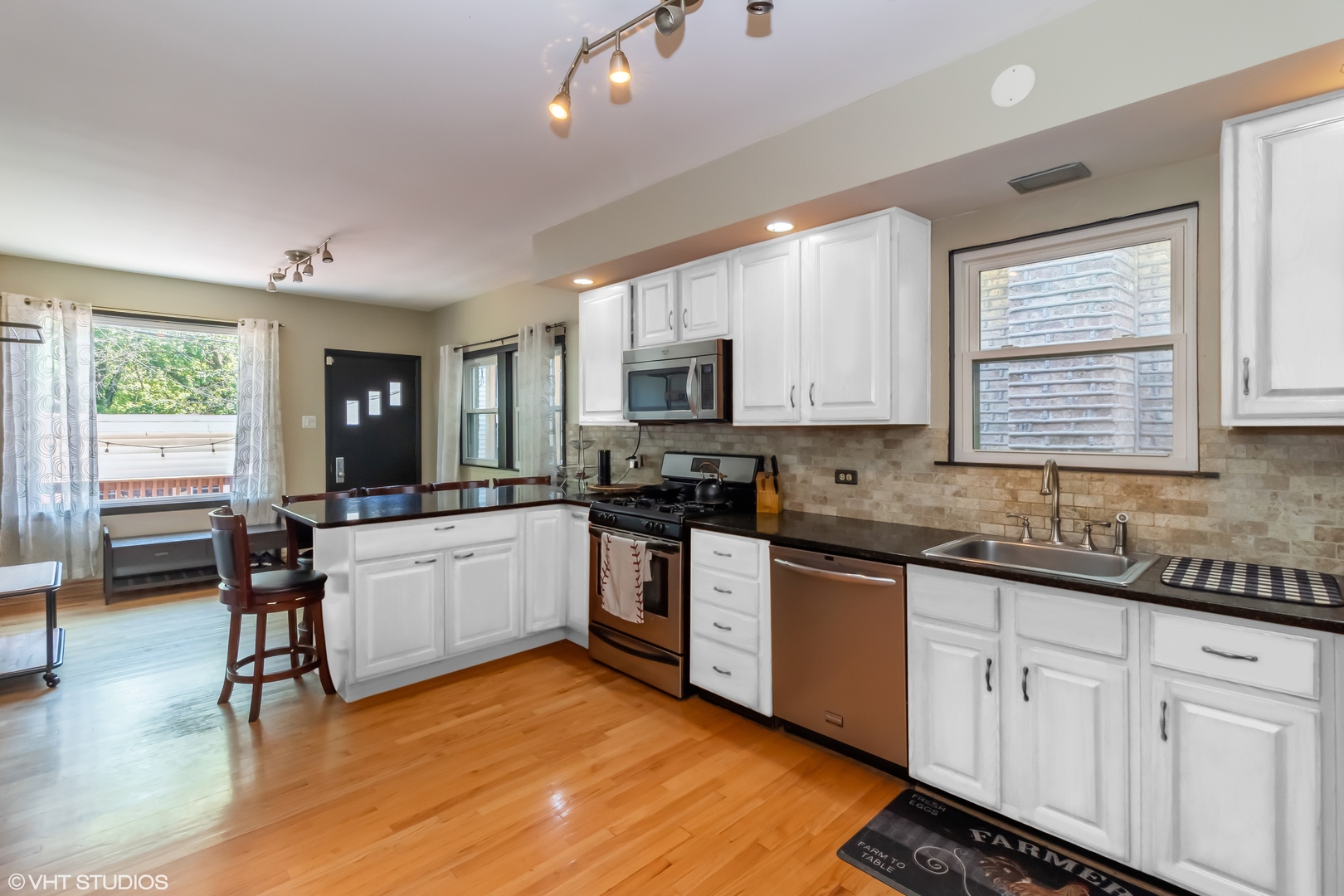 6129 North Mason Avenue Chicago, IL 60646 - Photo 5 of 22 a kitchen with stainless steel appliances granite countertop wooden cabinets a sink a stove a dining table and chairs