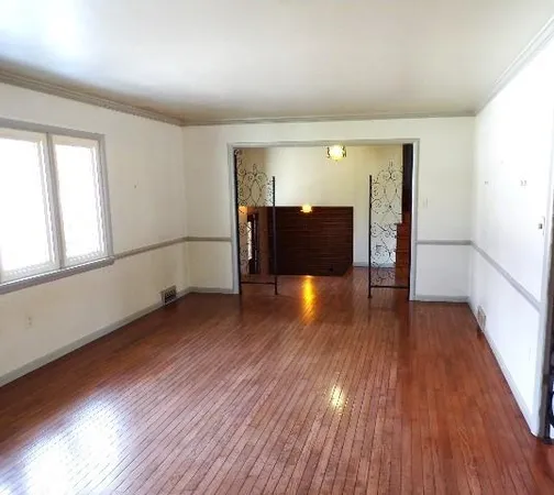 a view of a room with wooden floor and windows