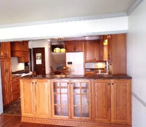 a view of an empty room with wooden floor and a fireplace