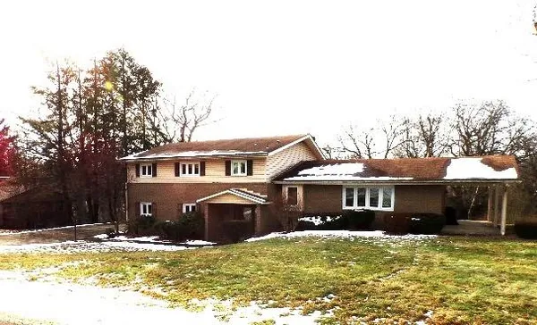 a front view of a house with a garden and trees