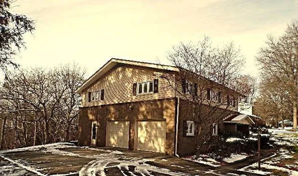a front view of a house with a yard covered in snow