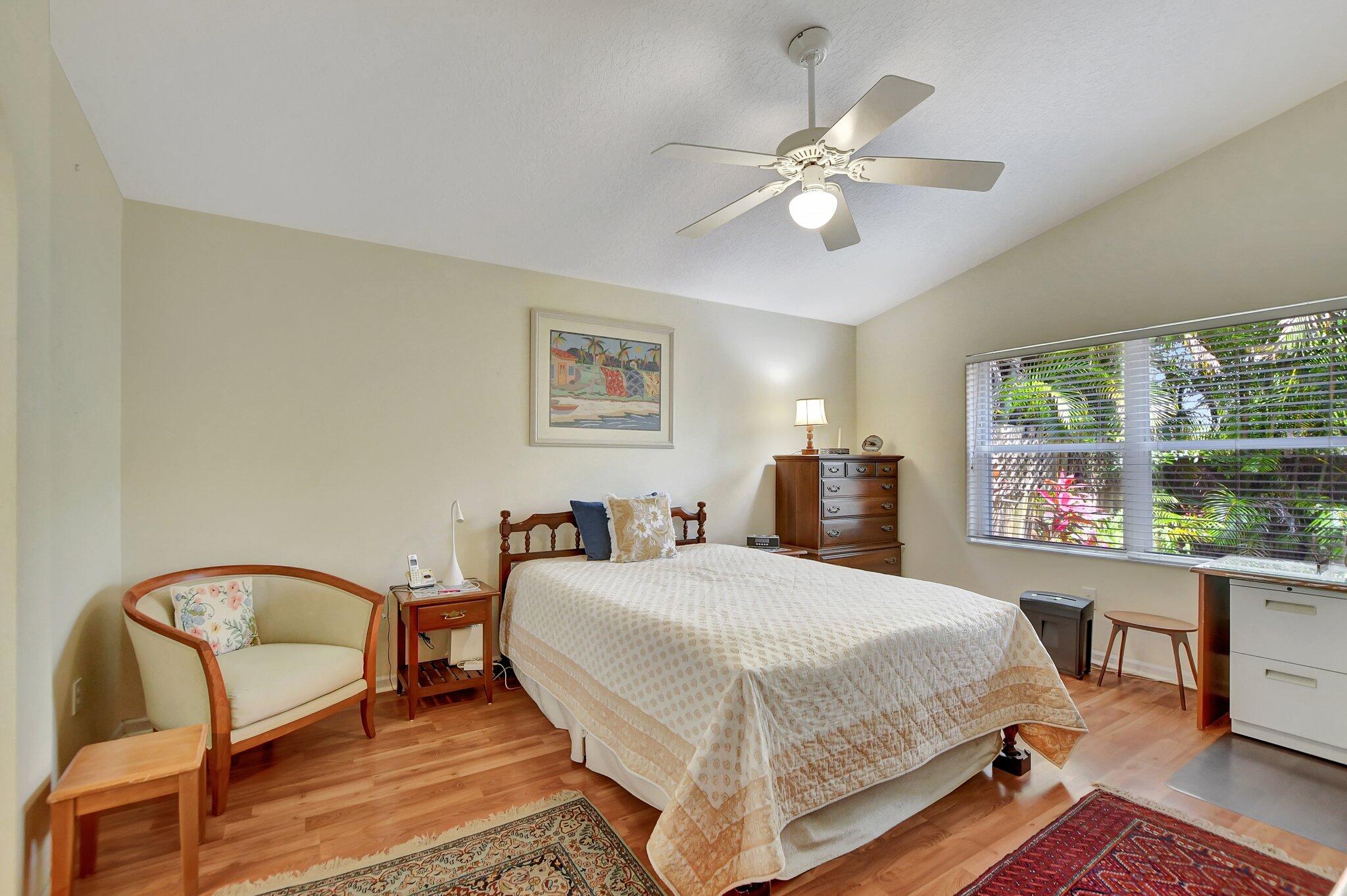 8853 Harrods Drive Boca Raton, FL 33433 - Photo 20 of 45 a bedroom with a bed a chandelier and a window