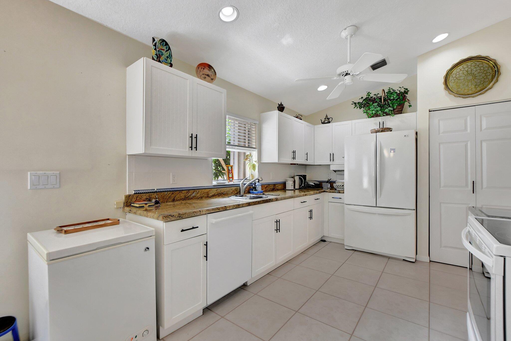 8853 Harrods Drive Boca Raton, FL 33433 - Photo 9 of 45 a kitchen with cabinets and window