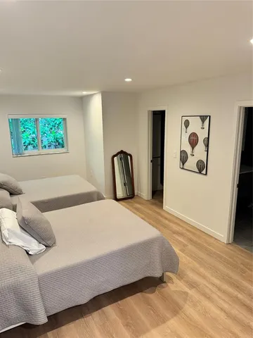 a bedroom with two beds and a large window