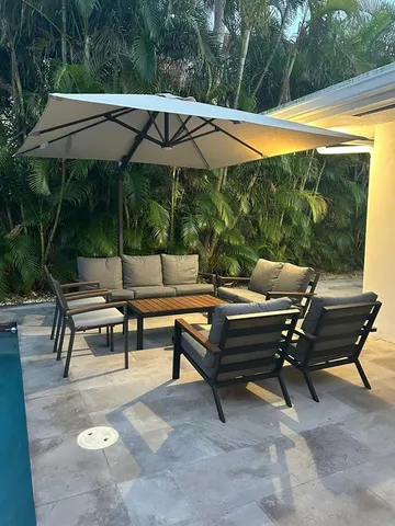 a patio with table and chairs and potted plants