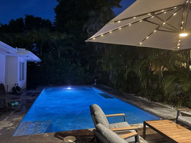 a view of a swimming pool with chairs in patio